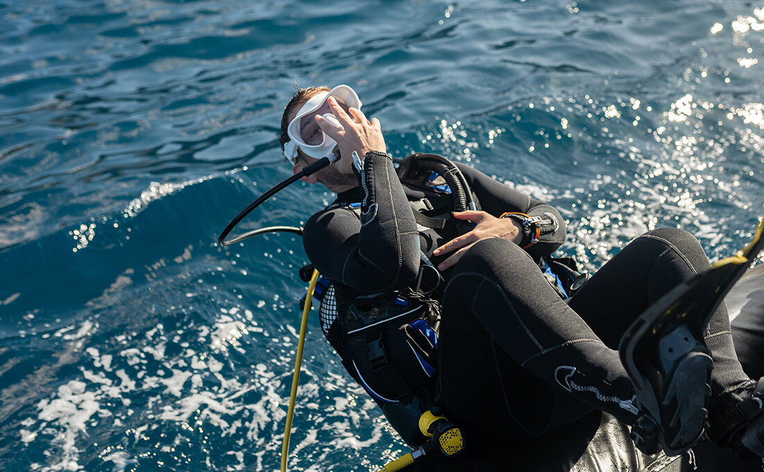 Taucher mit kompletter Ausrüstung beim Einstieg ins Freiwasser