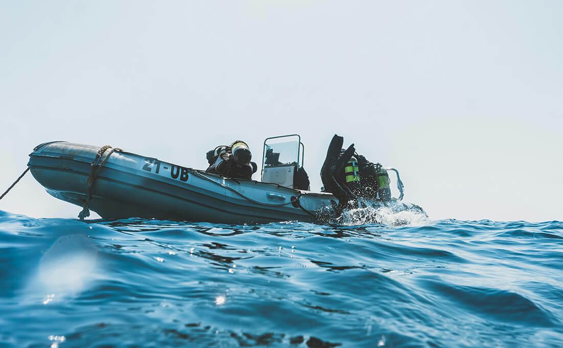 Taucher bereiten sich auf einem Schlauchboot auf einen Rettungstauchgang vor